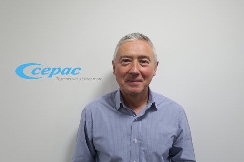 Portrait of Peter Coughlin with Cepac logo on wall behind him.